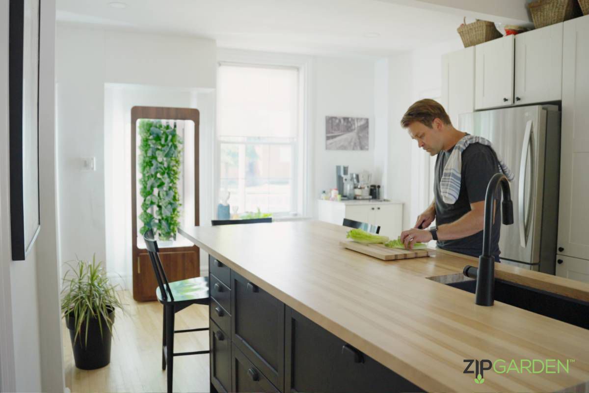 A man cutting up vegetables on top of a wooden counter.